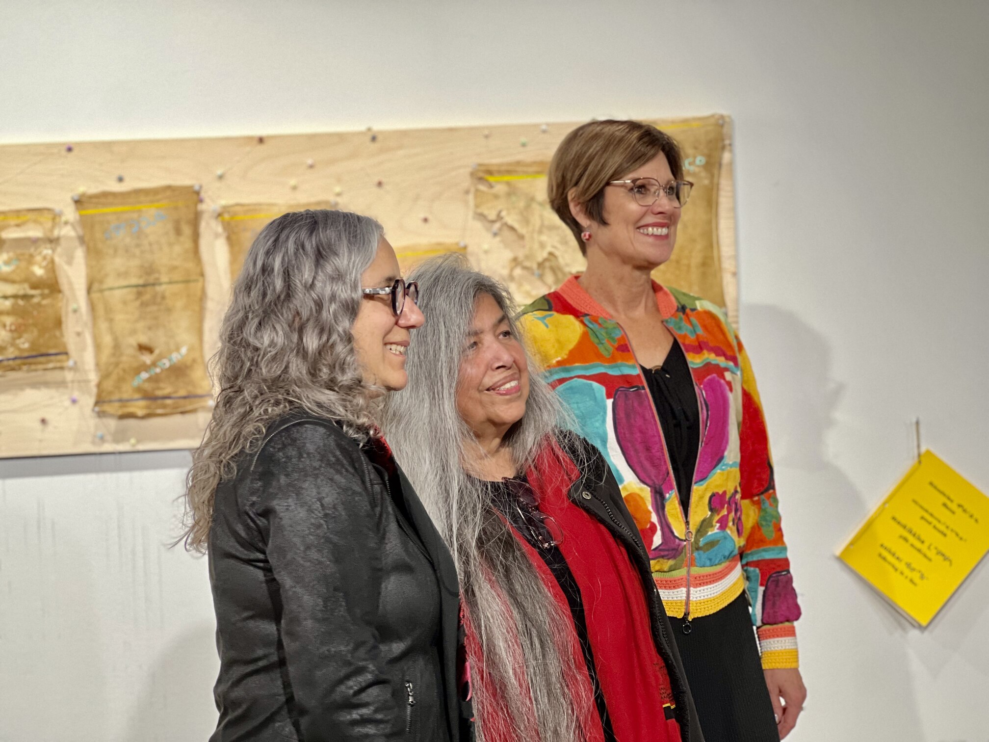 Pictured: Linda Young at her gallery show with CGPS Dean Debby Burshtyn (left) and supervisor Debbie Pushor (right). Photo credit: Connor Jay and Michael Olson 