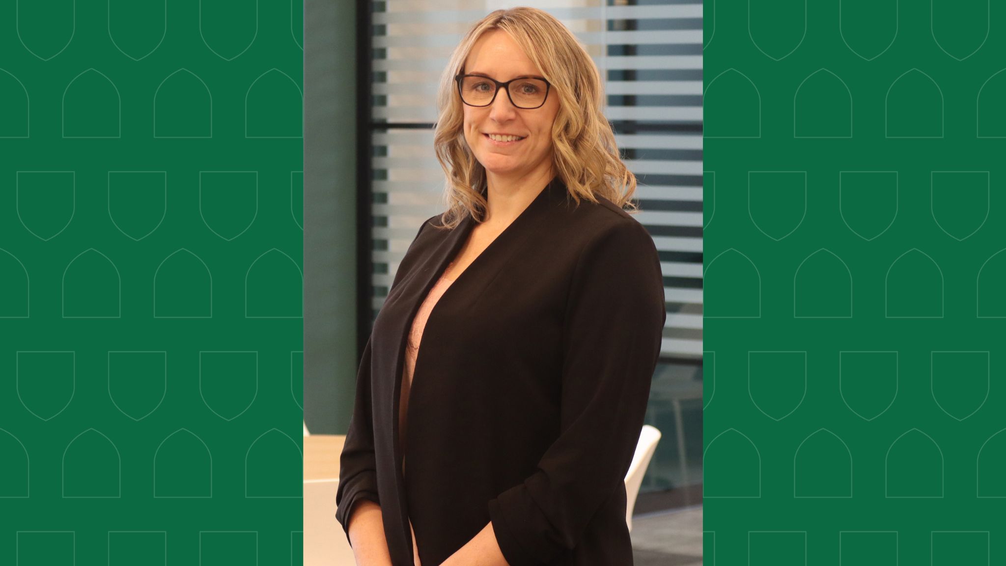 Pictured: Headshot of a woman wearing a blazer overlaid on a green background. 