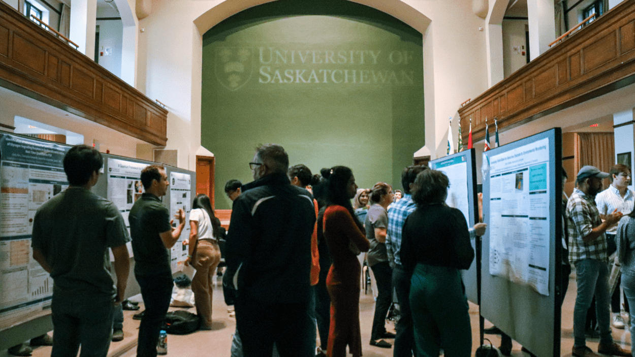 Pictured: Undergraduate student researchers present posters to judges at the SURE Summer Symposium. 