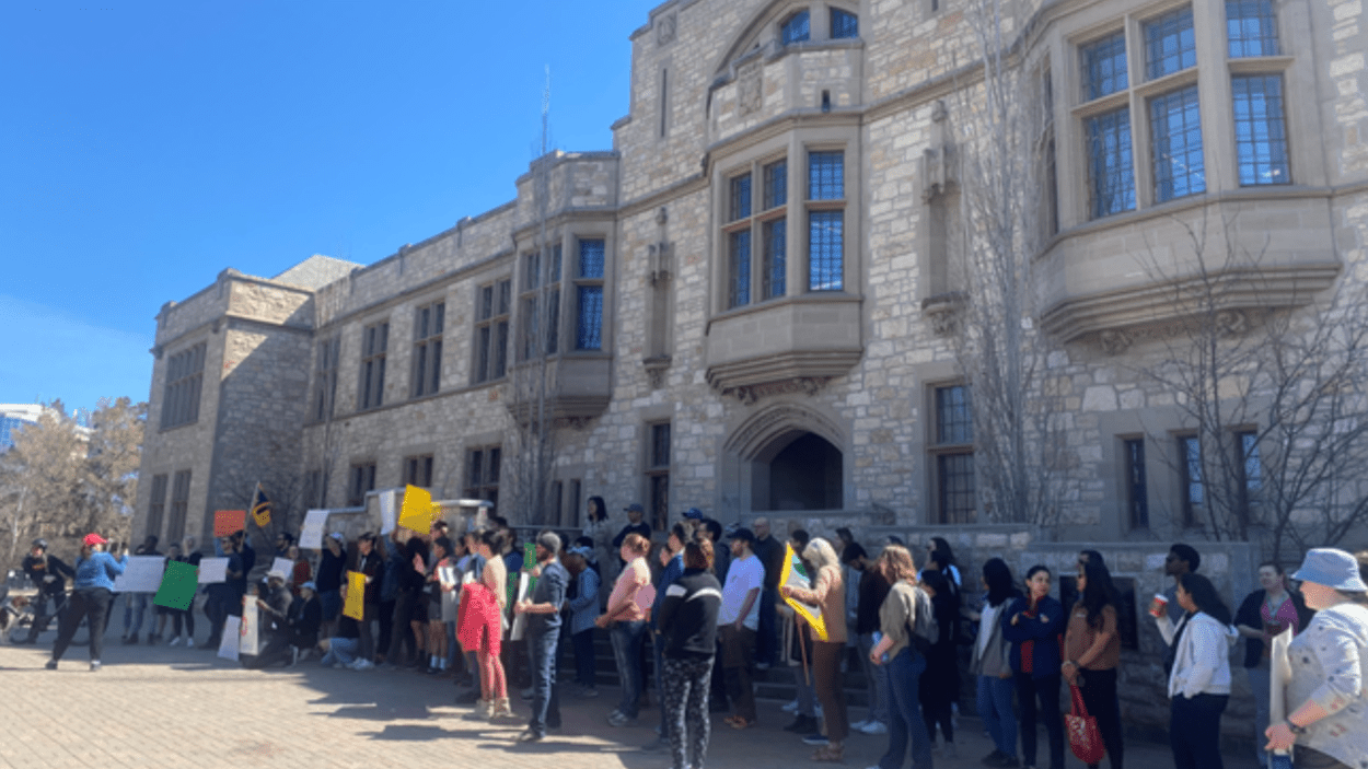 Pictured: Group of Support Our Science demonstrators with signs gathered in front of Peter MacKinnon Building at USask