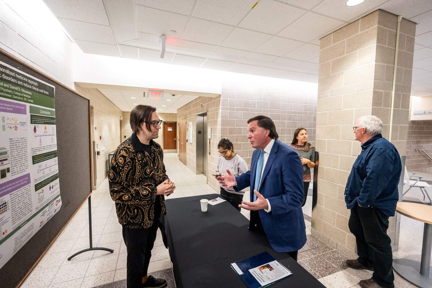 Pictured: Postdoctoral fellow Tyler Wenzel (PhD) discusses his research with Hon. Gordon Wyant Photo credit: Matt Smith